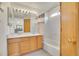 Bright bathroom with double sink vanity, large mirror, and tub-shower with curtain at 1214 S Akron Way, Denver, CO 80247