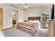 Large bedroom with a ceiling fan, a window with blinds, and a doorway to the bathroom at 1214 S Akron Way, Denver, CO 80247