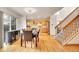 Open-concept dining area and kitchen with hardwood floors, island, and stainless steel appliances at 1214 S Akron Way, Denver, CO 80247