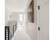 Bright hallway with white walls, white carpet and black metal railing at 8280 E 36Th Ave # 27, Denver, CO 80238