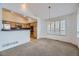 Open dining room with view into kitchen and neutral carpeting at 10054 W Vassar Pl, Lakewood, CO 80227