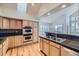 Spacious kitchen with light wood cabinets, granite counters, and stainless steel appliances at 10054 W Vassar Pl, Lakewood, CO 80227