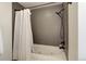 Clean, modern bathtub with gray tile surround and rainfall shower head at 1020 15Th St # 210, Denver, CO 80202