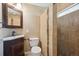 Bathroom showcasing a dark vanity, commode, decorative wall tiles, and walk-in shower with stylish fixtures at 13895 W Atlantic Ave, Lakewood, CO 80228