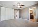 Spacious bedroom featuring plush carpet, a ceiling fan, and an attached bathroom for added convenience at 13895 W Atlantic Ave, Lakewood, CO 80228