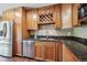 Close-up of a kitchen featuring stainless steel appliances, granite countertops, and wooden cabinetry at 13895 W Atlantic Ave, Lakewood, CO 80228