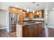 Well-equipped kitchen with stainless steel appliances, wooden cabinets, granite countertops, and hardwood floors at 13895 W Atlantic Ave, Lakewood, CO 80228
