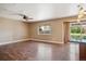 Spacious living room with hardwood floors, ceiling fan, and a sliding glass door to the backyard at 13895 W Atlantic Ave, Lakewood, CO 80228