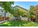 Back exterior showcasing a private yard with lawn and shade trees at 10262 Spotted Owl Ave, Highlands Ranch, CO 80129