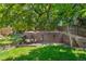 A spacious backyard features a wooden retaining wall, a stone patio area, and verdant lawn at 10262 Spotted Owl Ave, Highlands Ranch, CO 80129