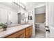 Bright bathroom featuring a large mirror, vanity with drawers, and a doorway leading into the bedroom at 10262 Spotted Owl Ave, Highlands Ranch, CO 80129