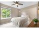 Serene bedroom with large window and a ceiling fan providing natural light and ventilation at 10262 Spotted Owl Ave, Highlands Ranch, CO 80129