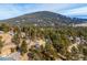 Aerial view showcases mountain home surrounded by a dense evergreen forest at 9189 Fallen Rock Rd, Conifer, CO 80433