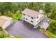 Aerial view of a home with a two-car garage, large driveway, and outdoor deck at 9189 Fallen Rock Rd, Conifer, CO 80433