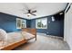Cozy bedroom features blue walls, carpet, and natural light streaming through two large windows at 9189 Fallen Rock Rd, Conifer, CO 80433