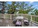 View of deck with outdoor table and four chairs and white railing, surrounded by trees at 9189 Fallen Rock Rd, Conifer, CO 80433