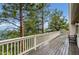 Exterior deck with white railing and views of the surrounding trees and mountains at 9189 Fallen Rock Rd, Conifer, CO 80433