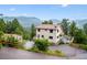 Two-story home with a surrounding mountain view, a large deck, and a two-car garage at 9189 Fallen Rock Rd, Conifer, CO 80433