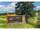 Entrance sign for Flying J Ranch Park with wooden post and stone base at 9189 Fallen Rock Rd, Conifer, CO 80433