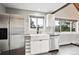 Bright kitchen with stainless steel appliances, a farmhouse sink, and large windows with scenic views at 9189 Fallen Rock Rd, Conifer, CO 80433