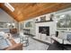 Cozy living room featuring wood ceilings, a fireplace, and large windows with views at 9189 Fallen Rock Rd, Conifer, CO 80433