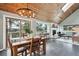 Open-concept living space with dining area, fireplace, wood ceiling, and access to a deck with stunning views at 9189 Fallen Rock Rd, Conifer, CO 80433