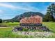 A Welcome to Conifer sign with stone base and a mountain backdrop at 9189 Fallen Rock Rd, Conifer, CO 80433