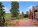 Backyard featuring a wood fence, lush landscaping, and a red brick staircase to the upper deck at 3266 Yale Dr, Broomfield, CO 80023