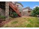 Backyard view highlighting stone and brick exterior, stairs to a deck, and lawn at 3266 Yale Dr, Broomfield, CO 80023