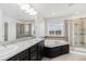 Bathroom featuring a large soaking tub, double vanity sinks, and walk-in shower at 3266 Yale Dr, Broomfield, CO 80023