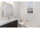 Clean half bathroom with modern vanity, stylish mirror, and neutral tile flooring at 3266 Yale Dr, Broomfield, CO 80023