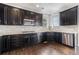 Stylish kitchen with stainless steel appliances, dark cabinets, and hardwood flooring at 3266 Yale Dr, Broomfield, CO 80023