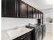 Laundry room featuring modern washer and dryer and dark cabinets above a sink with countertop at 3266 Yale Dr, Broomfield, CO 80023