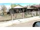 Charming single-Gathering home featuring a covered porch and a classic picket fence, with a carport on the right side at 4411 W Center Ave, Denver, CO 80219