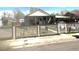 Charming single-Gathering home featuring a covered porch and a classic picket fence, with a carport on the right side at 4411 W Center Ave, Denver, CO 80219