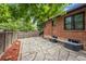 Landscaped stone patio and backyard with brick home, mature trees, and wooden fence at 1010 Euclid Ave, Boulder, CO 80302