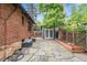 Exterior view of brick house featuring a stone patio, garden, mature tree, and backyard structure at 1010 Euclid Ave, Boulder, CO 80302