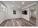 Bright basement with wood-look floors, recessed lighting, and a large wall-mounted television at 1010 Euclid Ave, Boulder, CO 80302