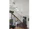 A staircase with dark-stained handrail and ceiling fan leads to the upper level in this bright home at 1010 Euclid Ave, Boulder, CO 80302