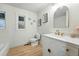 Stylish bathroom featuring wood-look floors, updated vanity, and modern fixtures at 3067 Robin Way, Denver, CO 80222