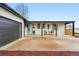 Inviting home exterior showcasing a covered porch with chairs and an attached garage at 3067 Robin Way, Denver, CO 80222