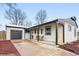Charming home features a covered porch, modern exterior paint, and a well-manicured lawn at 3067 Robin Way, Denver, CO 80222