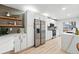 Modern kitchen with stainless steel appliances, white cabinetry, and open shelving at 3067 Robin Way, Denver, CO 80222