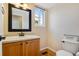 Cozy half bath with wooden vanity, decorative mirror, and bright natural light at 12535 Forest View St, Broomfield, CO 80020