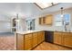 Bright eat-in kitchen features a tile countertop island, wood cabinets, and stainless steel appliances at 12535 Forest View St, Broomfield, CO 80020