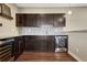 Stylish basement bar area with custom cabinetry, a sleek backsplash, and modern wine fridge at 2601 Loyd Cir, Parker, CO 80138