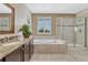 Bright bathroom featuring double sink vanity, soaking tub and separate glass enclosed shower at 2601 Loyd Cir, Parker, CO 80138