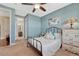 Charming bedroom with a metal bed frame, a ceiling fan, and a bright blue accent wall at 2601 Loyd Cir, Parker, CO 80138