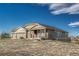 Exterior shot of a tan and brick home with a three-car garage and a covered front porch at 2601 Loyd Cir, Parker, CO 80138