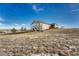 Rear exterior view of a tan and white house with a walkout basement, a yard, and an uphill slope at 2601 Loyd Cir, Parker, CO 80138